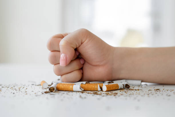 Hand crushing cigarettes — IRW Nederland stop-smoking clinic website hero